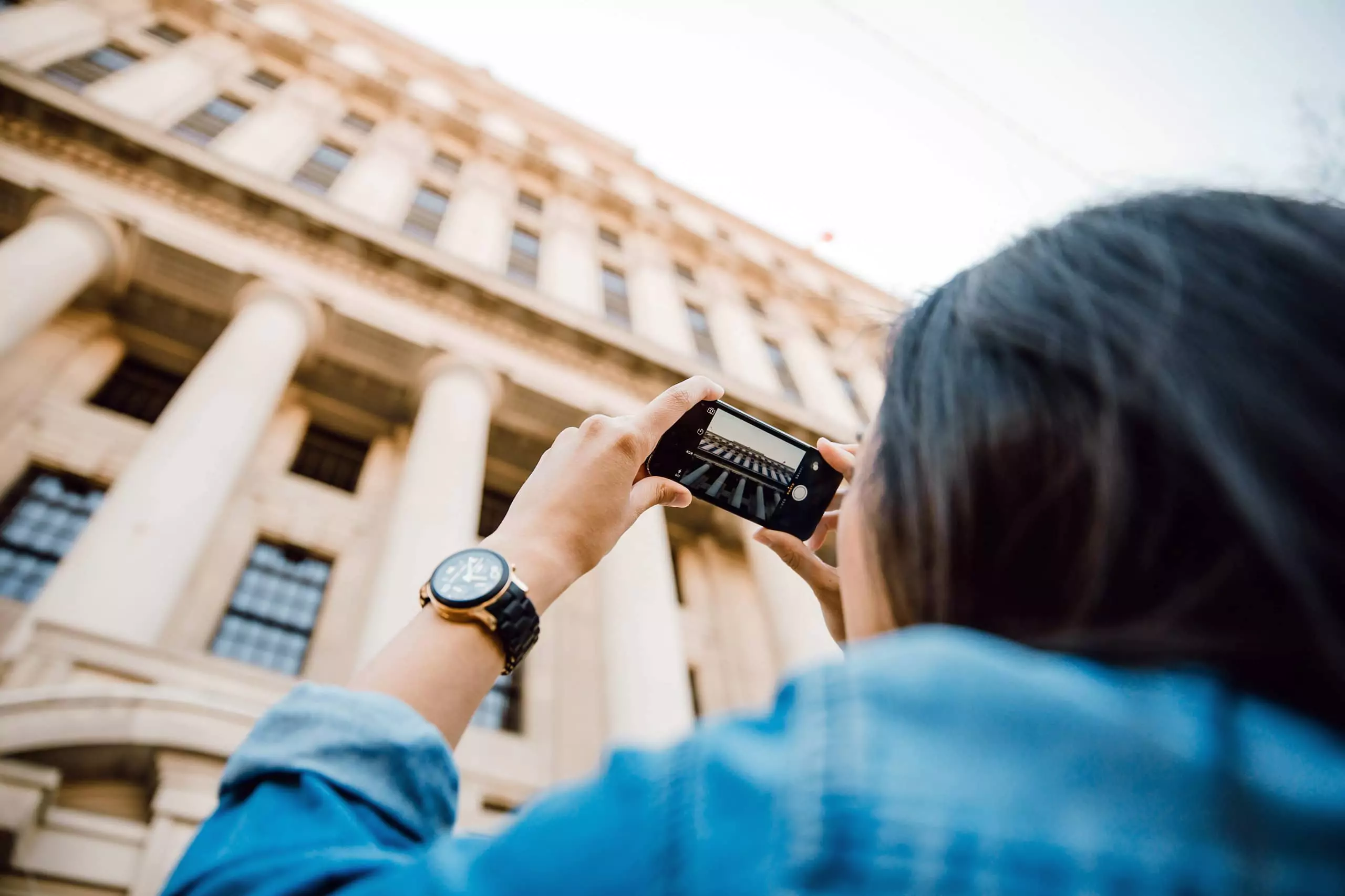 Woman taking picture of a building.